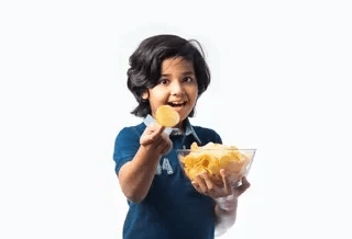 Boy holding bowl of chips